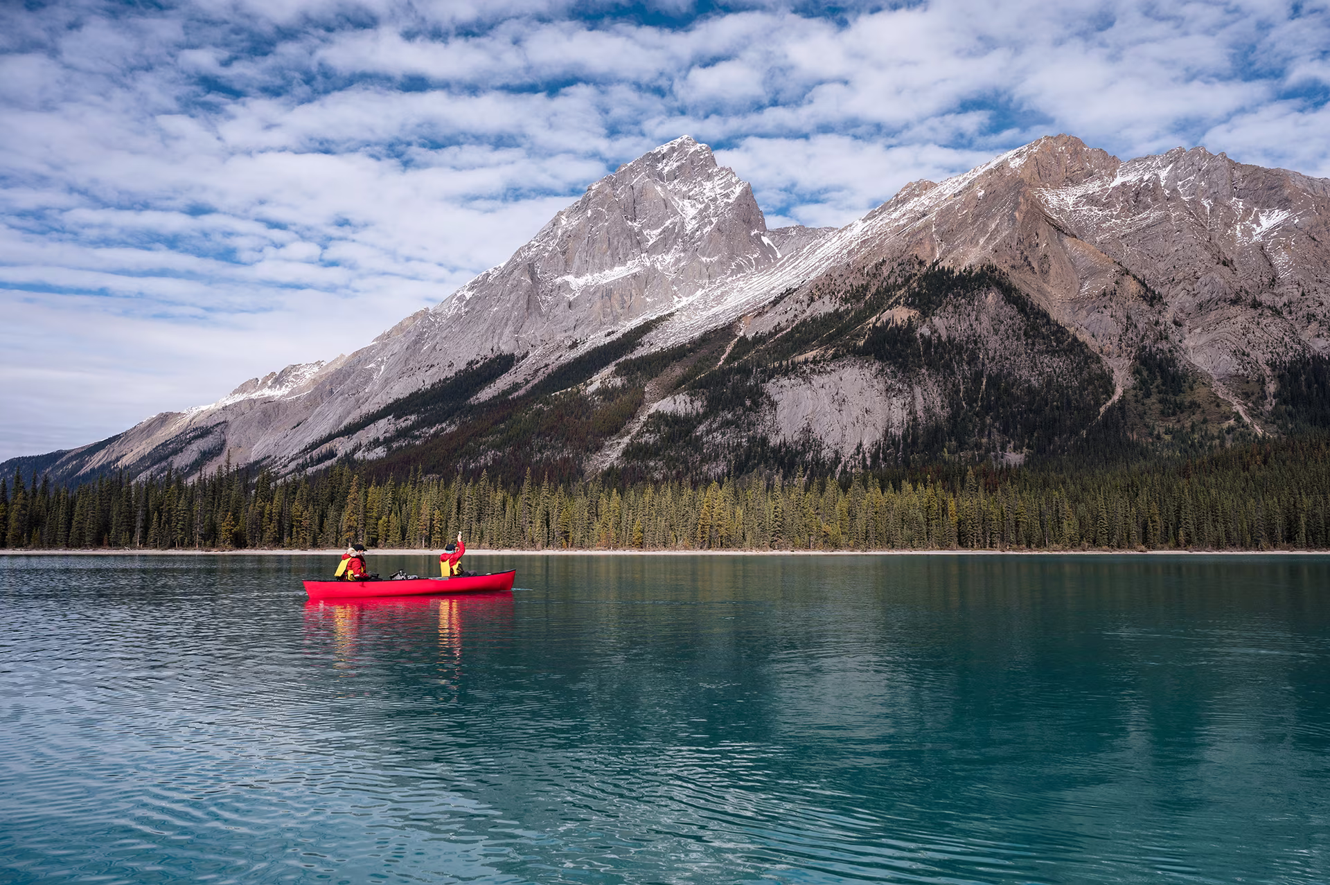 Canoeing on a lake surrounded by mountains.